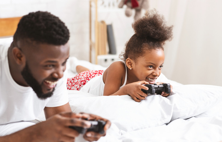 father playing video games with daughter